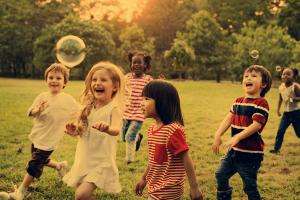 Children playing outdoors with bubbles